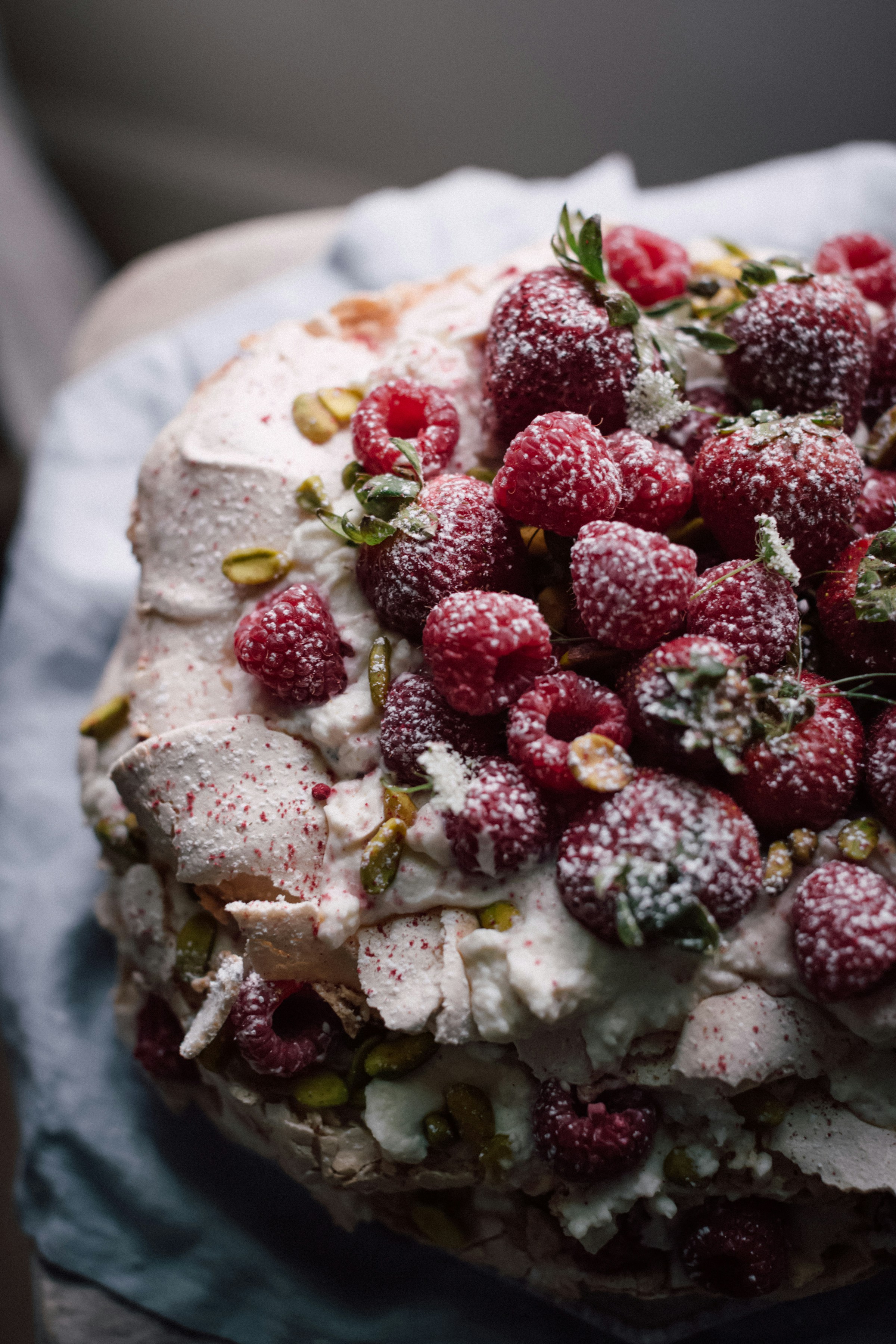 Layered cake with cream, raspberries, and pistachios