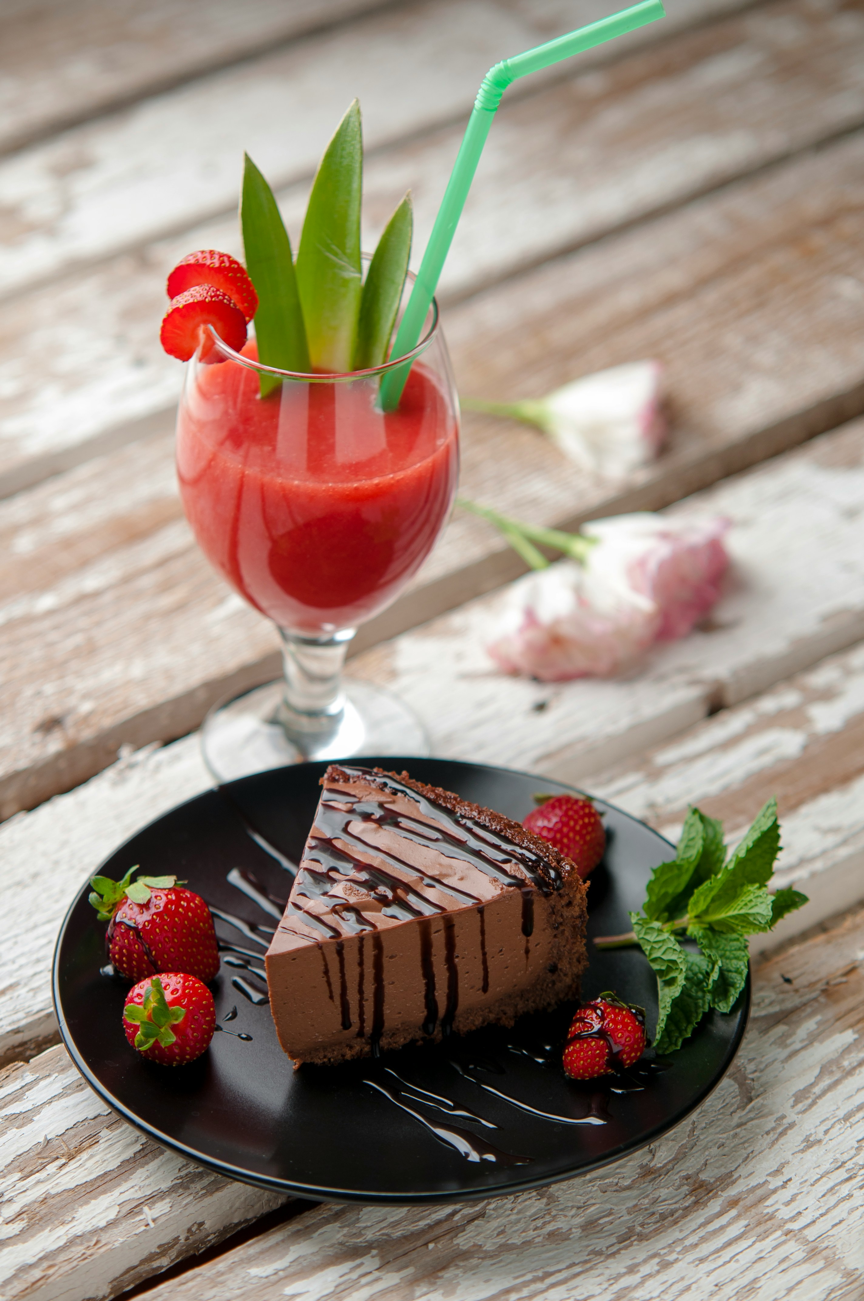Chocolate cake beside a glass of strawberry daiquiri
