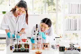 Two women in a chemistry lab performing an experiment