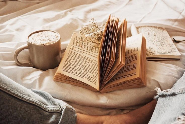 Book open on bed with coffee
