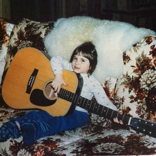 Melissa playing guitar as a young child