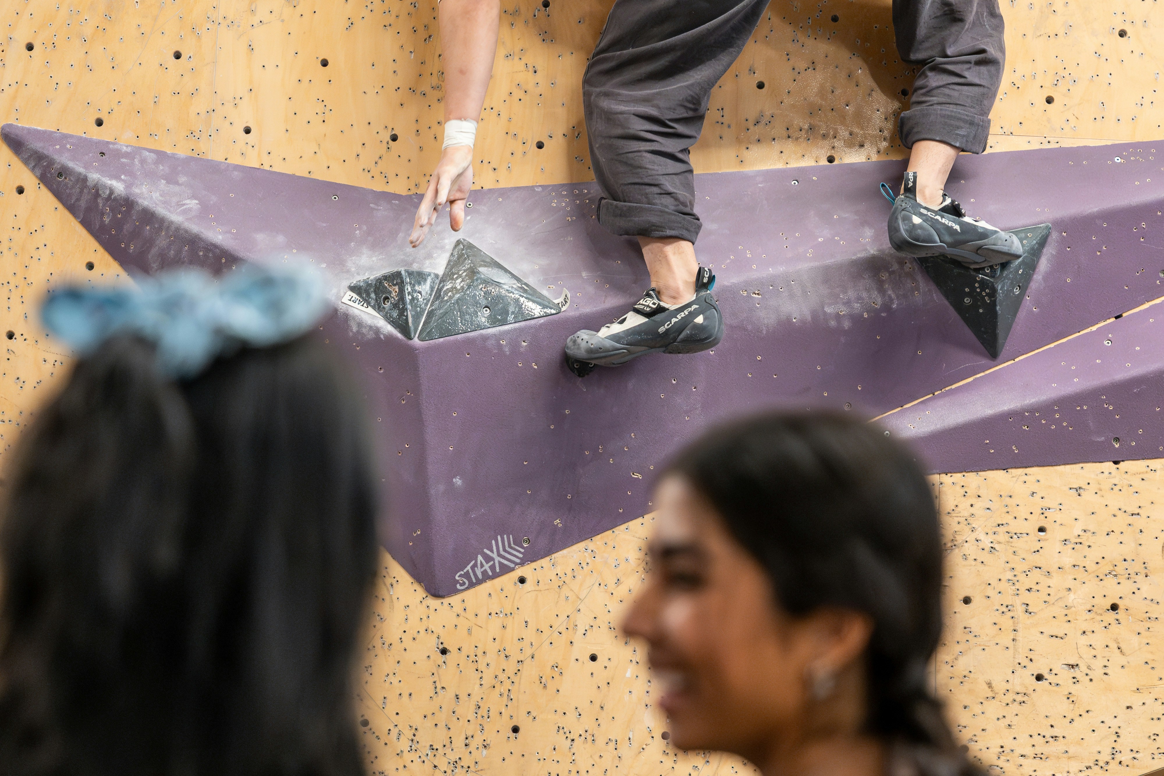 bouldering shot of climbing shoes between people's heads