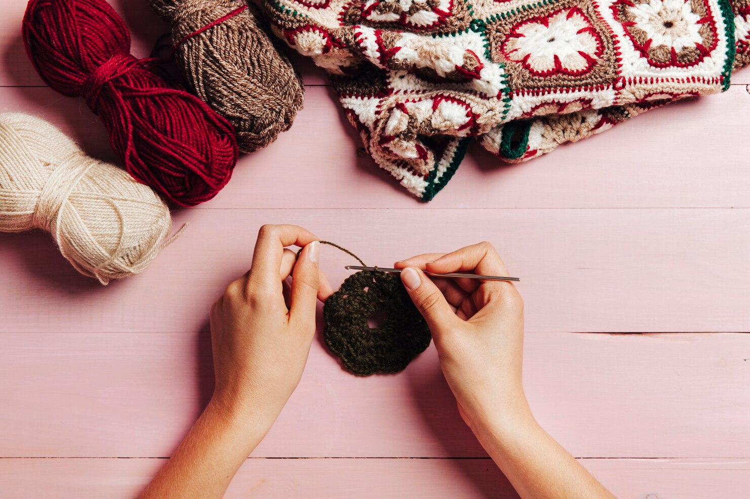 Hands of a woman crocheting using a crochet hook