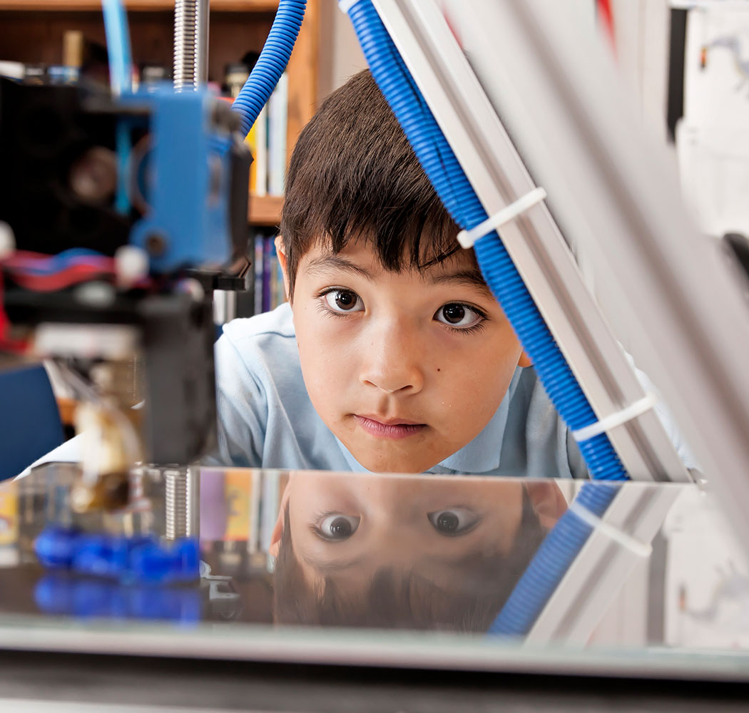photo: young boy watching 3D printer work