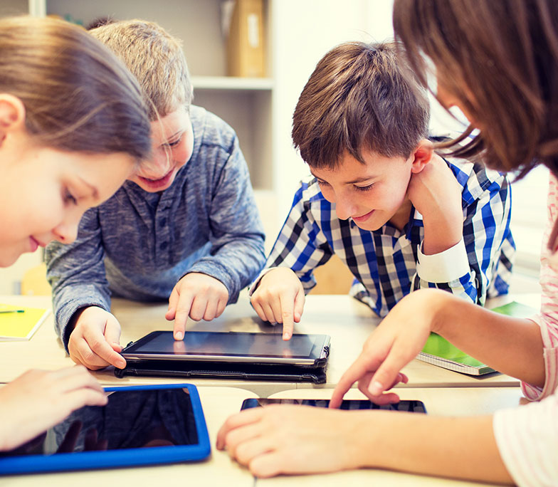 icon: group of students at table leaning over tablets and smiling