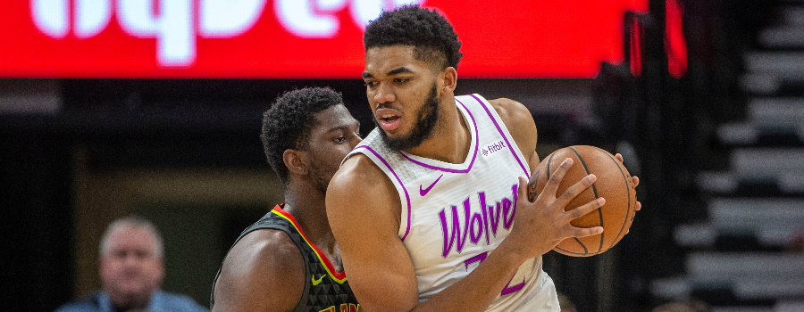 Minnesota Timberwolves center Karl-Anthony Towns (32) backs towards the basket as Atlanta Hawks guard Kent Bazemore (24) plays defense in the first half at Target Center.