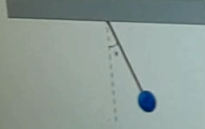 A ball is attached to a string hanging from the ceiling, forming