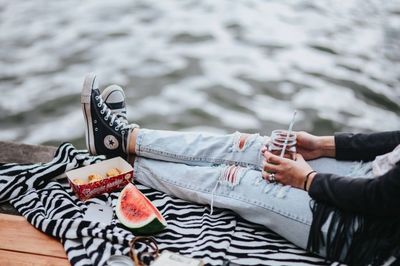female, woman, lake, dock, picnic, watermelon, converse, sneakers, ripped, jeans