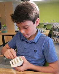Tony Rossi works on his 3-D printer house, one of many projects students work on during Innovative Lab