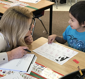 Literacy expert Patti Konarska helps a student with letters (Photo courtesy of Kyle Mayer)