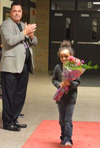 Superintendent Tom Reeder applauds as first-grader Kiara Thomas enters the building