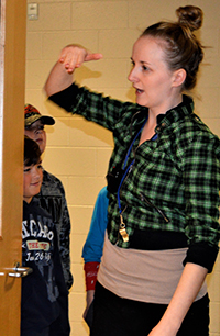 Teacher Linda Tata lines students up outside classroom door and lets them in single file so they see the room as a “learning space”