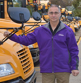 Don Hebeler, Wyoming Public Schools director of operations and support services, stands near the bus fleet. He and directors statewide need more drivers