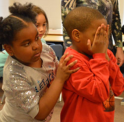 Second-grader Josiah Sutton sails through the Lake of Trust, pushed by a classmate