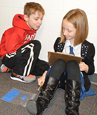 Third-graders Justine Meade and Julian Witt use trial-and-error to draw different shapes with the same area