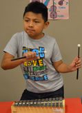 A student does a little dance while playing the glockenspiel