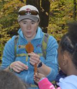 Naturalist guide Kelly Morrissey describes a beech leaf to students on the trail of Rosy Mound Natural Area