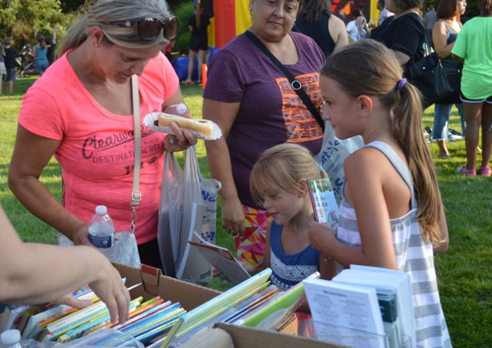 Mom Hasiba Sejdinovic helps daughters Ajla and Adelina pick out free books