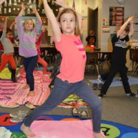 Maddie Stanton watches a yoga video to see how to do a pose