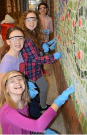 Third-graders caught smiling mid-grout are, from front to back, Joclynn Burholder, Ava Peterson, Izzy Field and Jaqlin Kraft