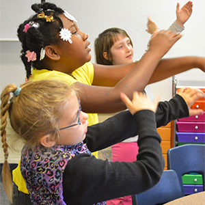 Students “arm spell,” a multi-sensory approach that helps them remembers sounds