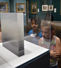 Third-graders Madileena Longoria and Kadinn Maddox view art on display