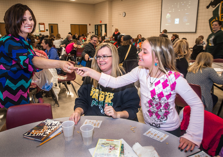 Gregoria Nava hands Marisa Vanderveen her winning ticket, which she could exchange for a book