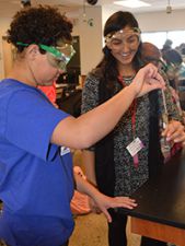 Fifth-grader Samantha Harris works on a chemical reaction with sophomore Maxine Osorio in Accelerated Chemistry class