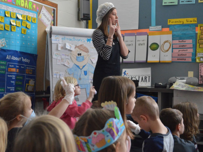 TKrockstarteacher18-1 To make contractions fun, first-grade teacher Brittany Brown uses surgical masks, latex gloves and Band-Aids to teach the lesson
