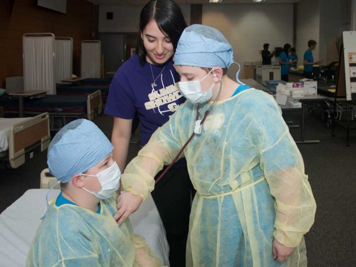 TechCenterSummerCamp3 Murphy Hossink, sixth grade, Highlands Middle; Camp volunteer Naideli Loyo, senior, Wyoming High; and James Dubin, eighth grade, North Rockford Middle, learn how to listen to the heart