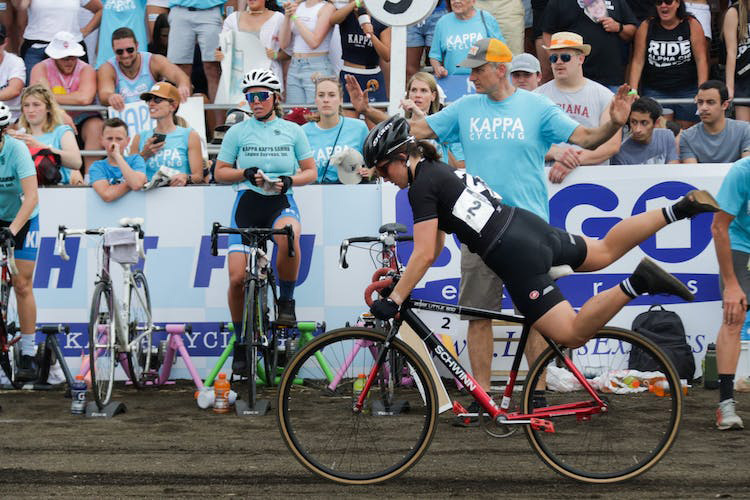 A member of Alpha Chi Omega's bike team mounts her bike April 22, 2022, at Bill Armstrong Stadium during the women's Little 500 race. To switch riders, teams could either use two bikes or one bike.