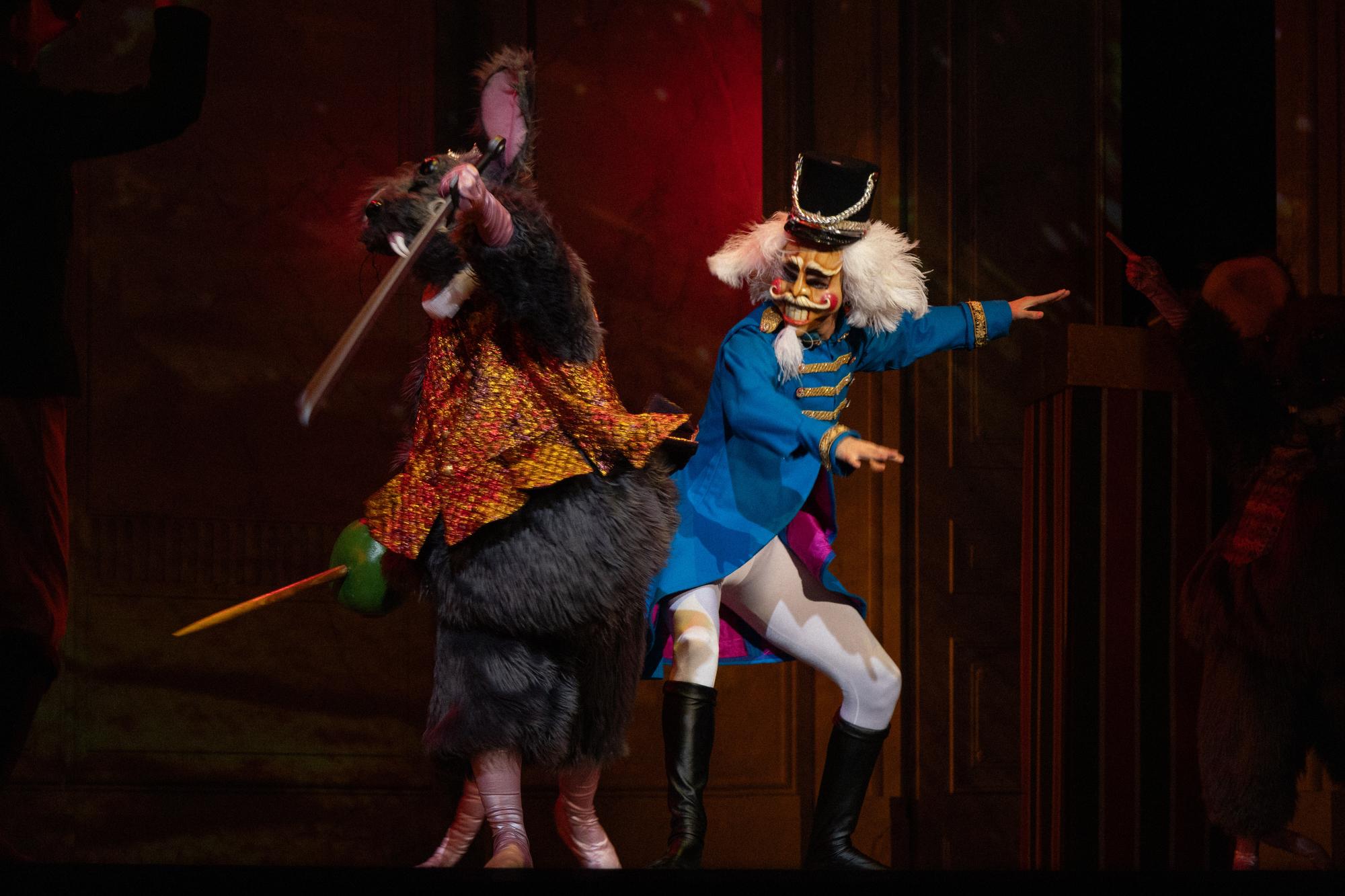 A giant rat and the nutcracker fight on stage with prop swords.