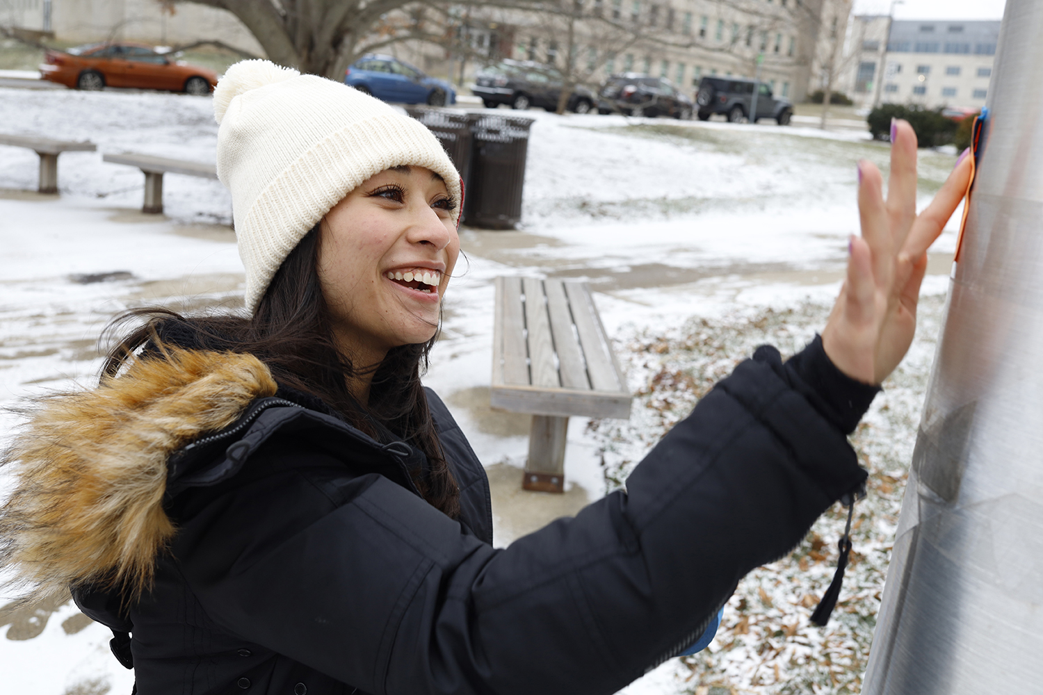 a woman pushes the sticky note on the pole