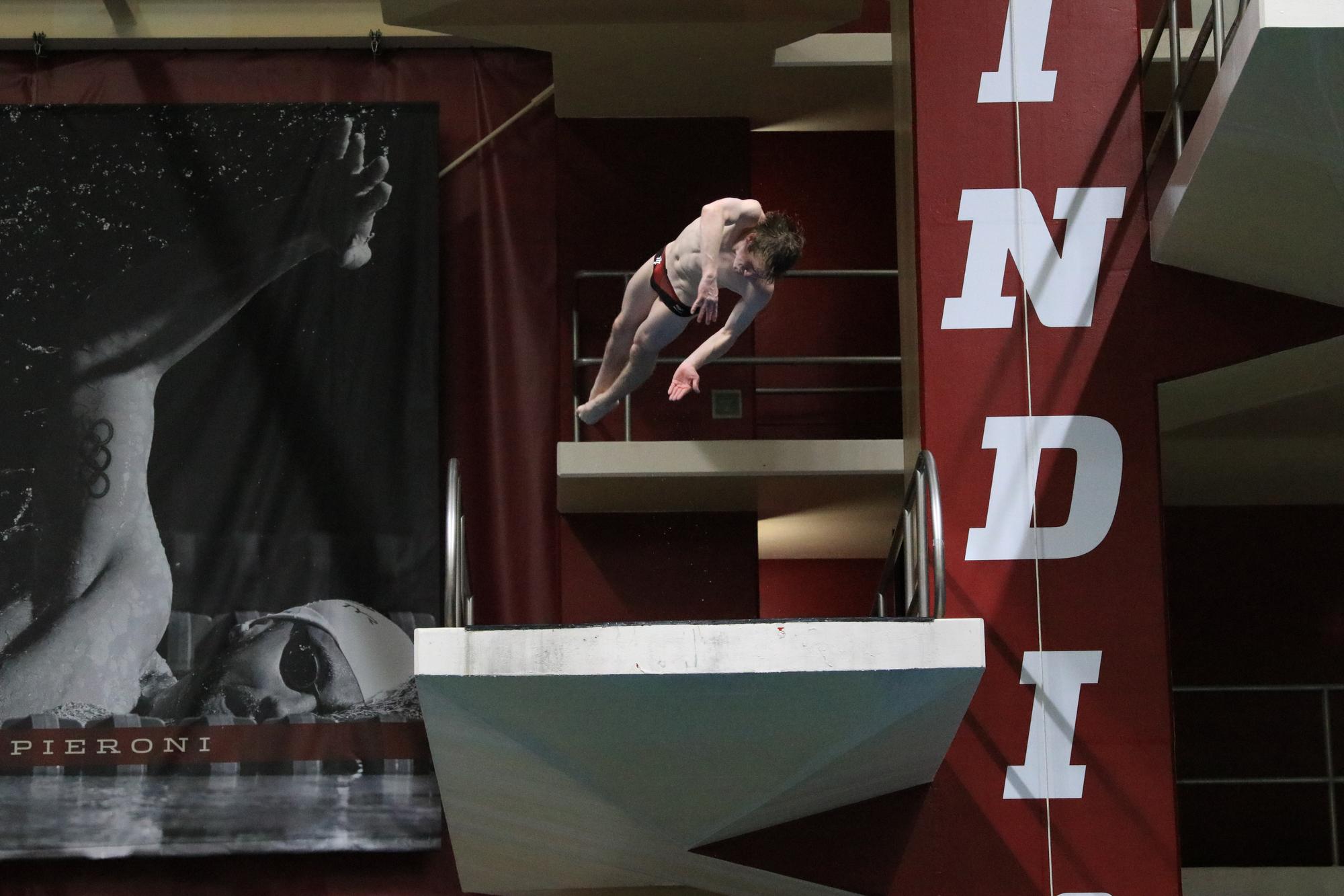 A diver jumping off a platform and beginning to twist in the air
