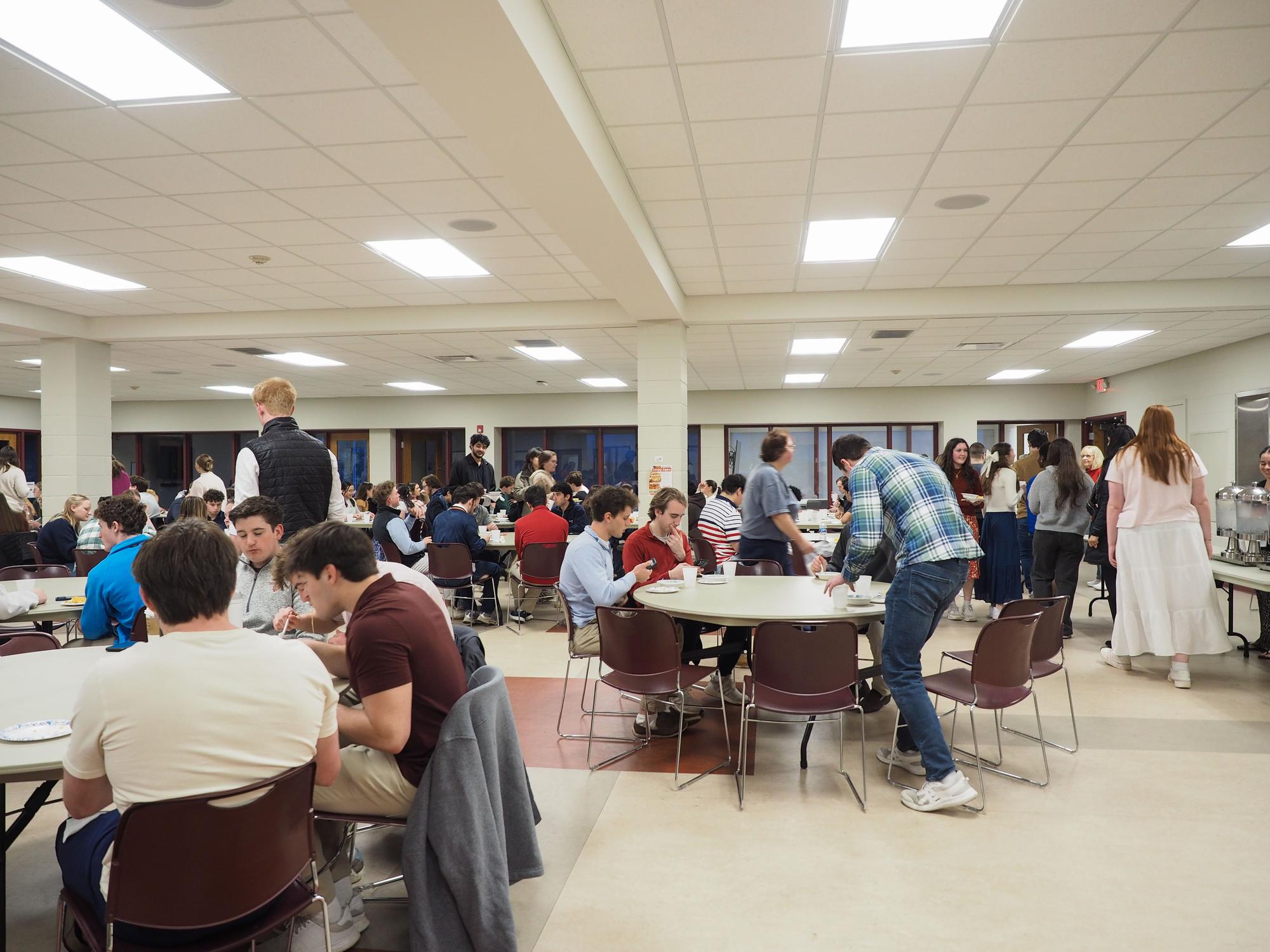People gather around tables in a large room