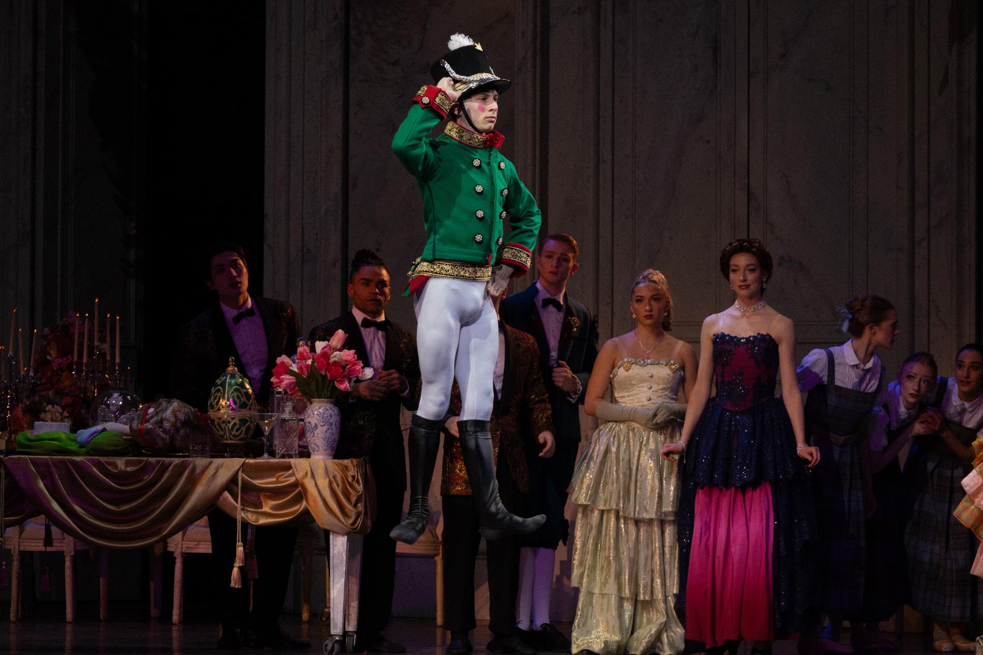 A dancer dressed as a soldier in green jump straight off the floor.