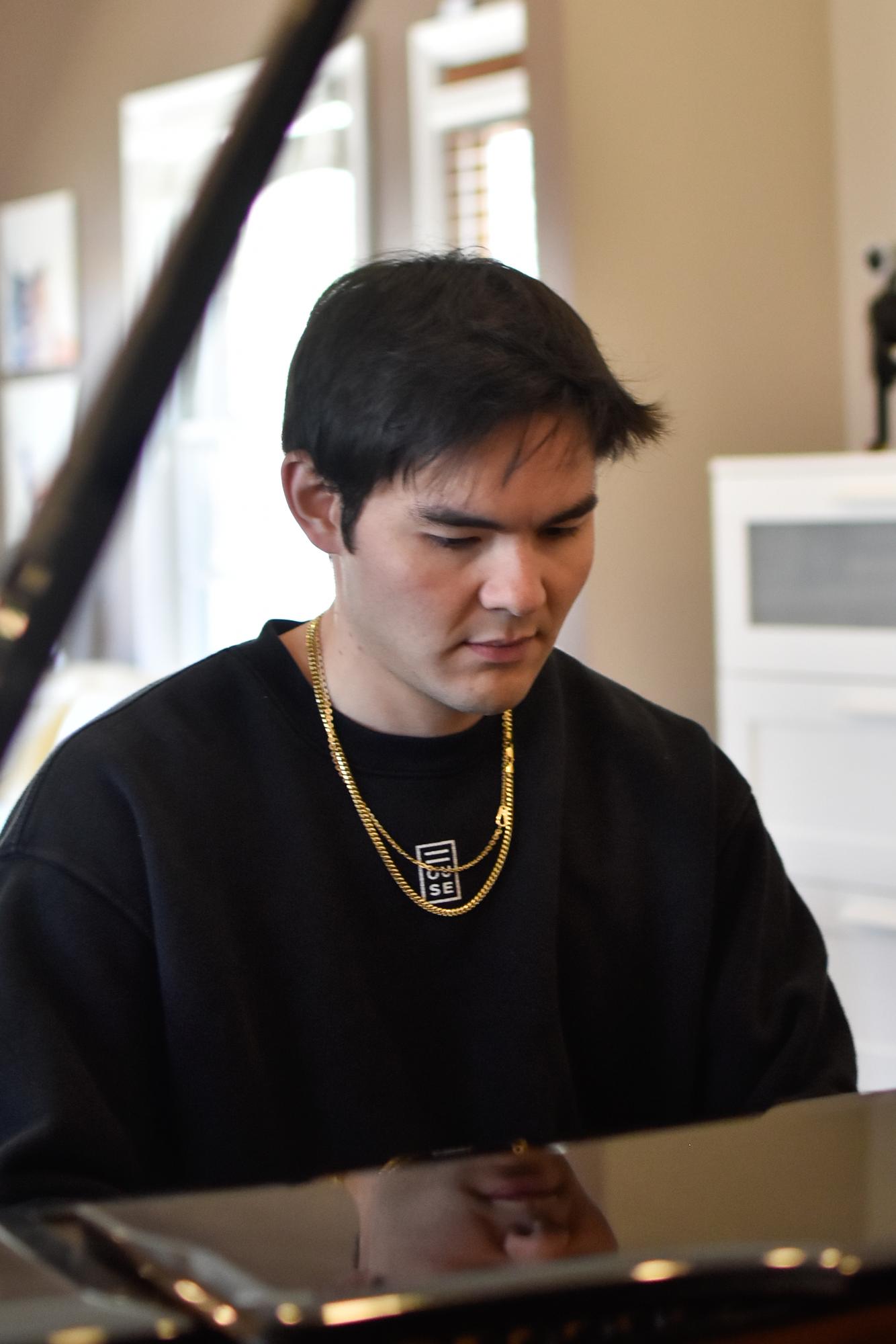 Someone sitting focused at a piano.