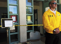 Chad Trujillo, an employee of Santa Fe Protective Services, stands in front of Zimmerman Library on Monday to keep students from entering the building that caught fire Sunday night.