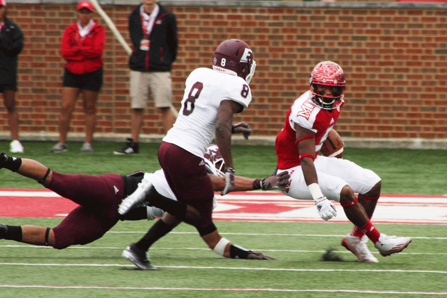 Senior wide out Dawan Scott tries to turn the corner and get past two Eastern Kentucky University defenders 
