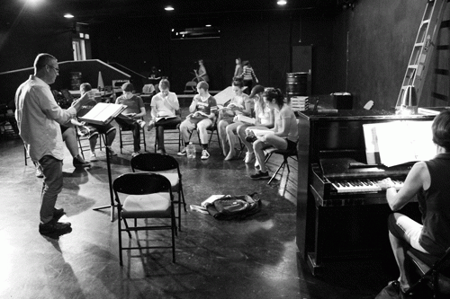 Music director Stephen Lytle leads the cast in rehearsal preparing for their opening night Oct. 2. Considered a rock opera, “Rent” has been popularized by its intricate but beautiful music