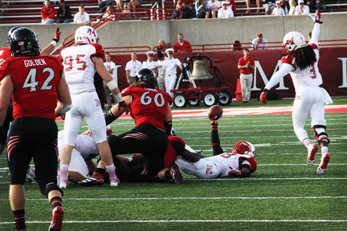 Miami University redshirt senior linebacker Chris Wade recovers a fumble against the University of Cincinnati during Miami’s 14-0 loss as senior cornerback Dayonne Nunely (right) celebrates. 