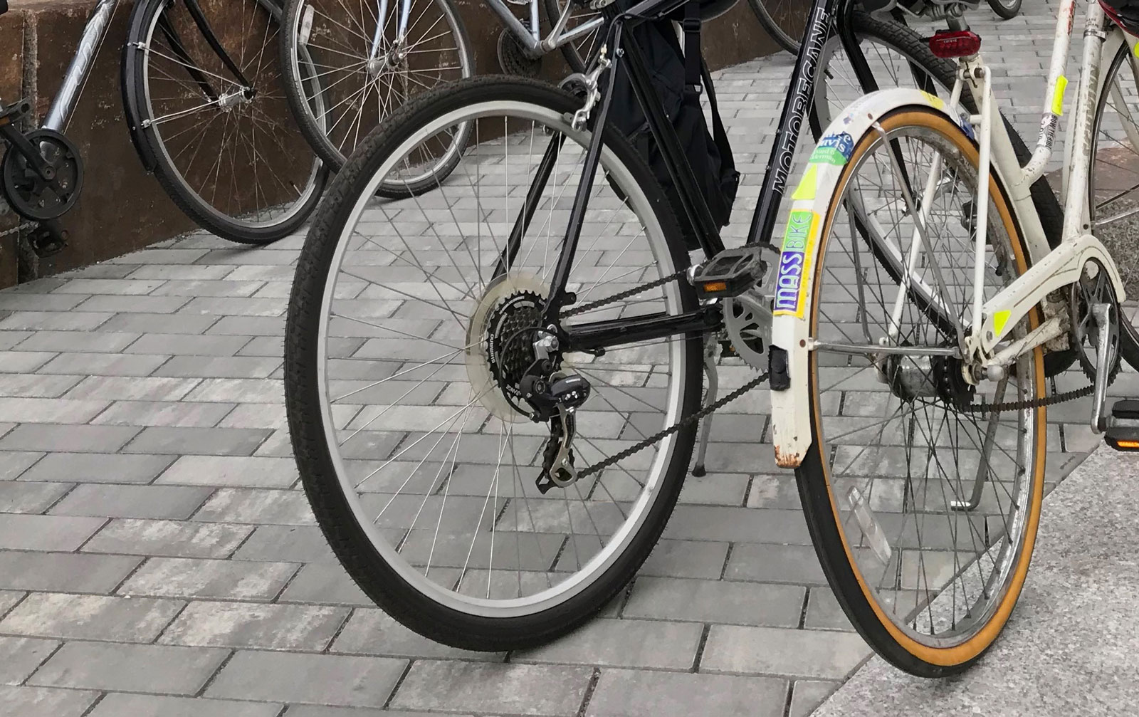 Two bicycles parked on walkway