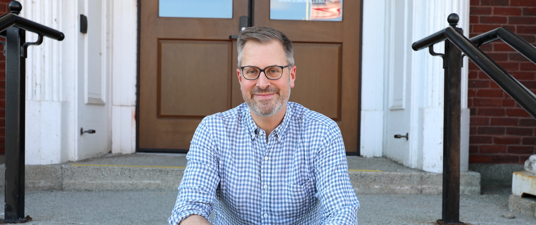 Mayor Jake Wilson sitting on the steps outside City Hall. 