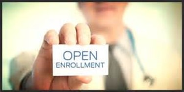 Person holding a card that reads "open enrollment".
