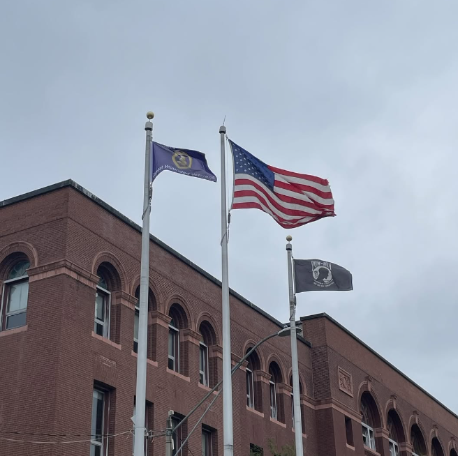 The Purple Heart flag flying next to an American Flag outside Somerville High School. 