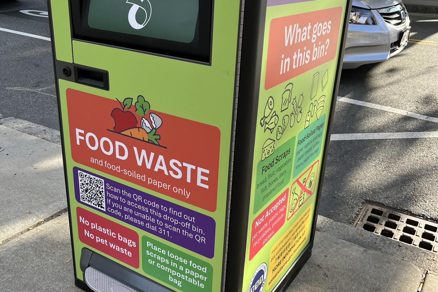 A closeup of a yellow and orange food waste drop off bin. 