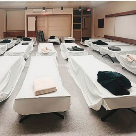 Interior of winter warming center with empty beds and pillows. 