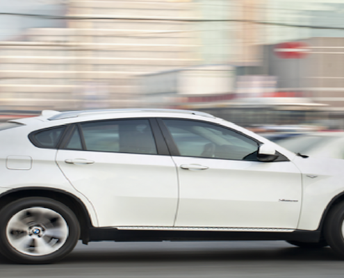 White car driving fast, speeding alert feature with Simplytrak.