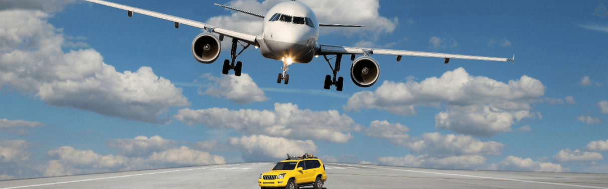 Airplane flying over vehicle on the runway