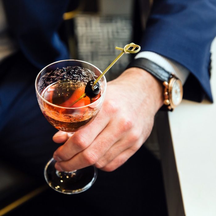 up close pink cocktail adorned with berries